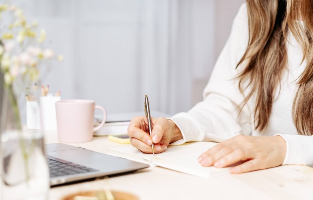 A picture of a lady writing in a note book