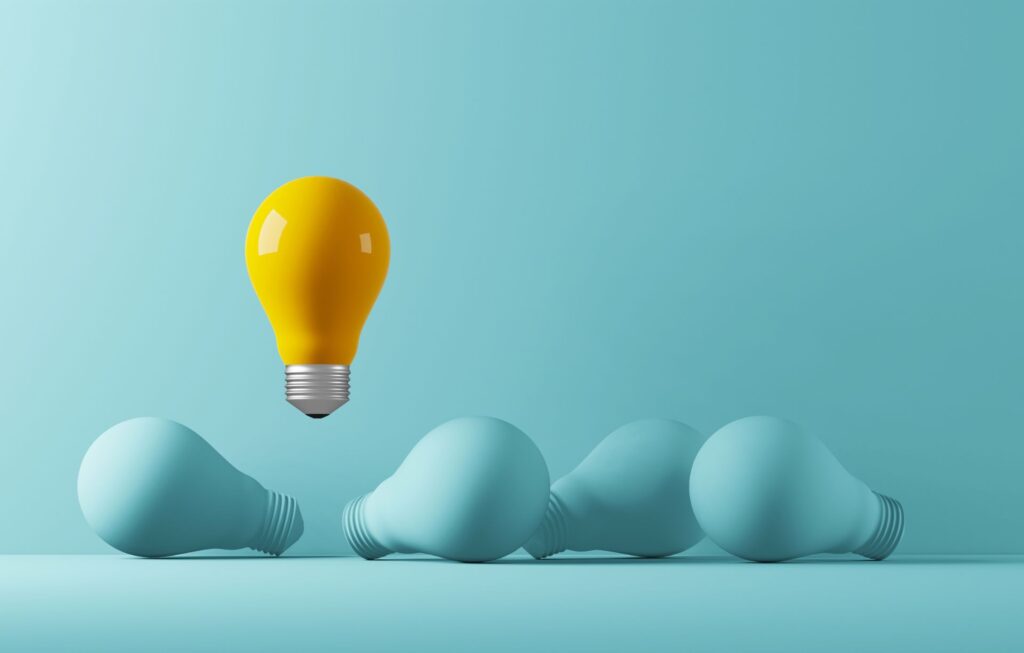 Yellow lightbulb standing out among blue lightbulbs, representing brand identity and standing out from competitors