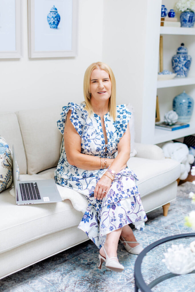 A photo of Yvette Craig in a blue and white dress sat on the sofa